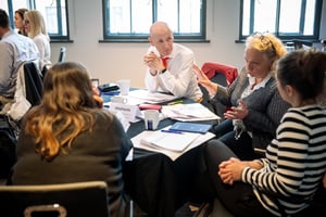 A group of team members engaged in a Strengthify Team Workshop, reviewing their strengths and discussing opportunities for collaboration.