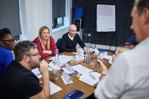 A public sector team engaged in collaborative team development during a manager-led strengths-based away day.