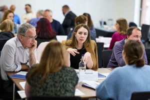 A diverse team engaged in a collaborative meeting, discussing ideas and sharing insights in a professional workspace.